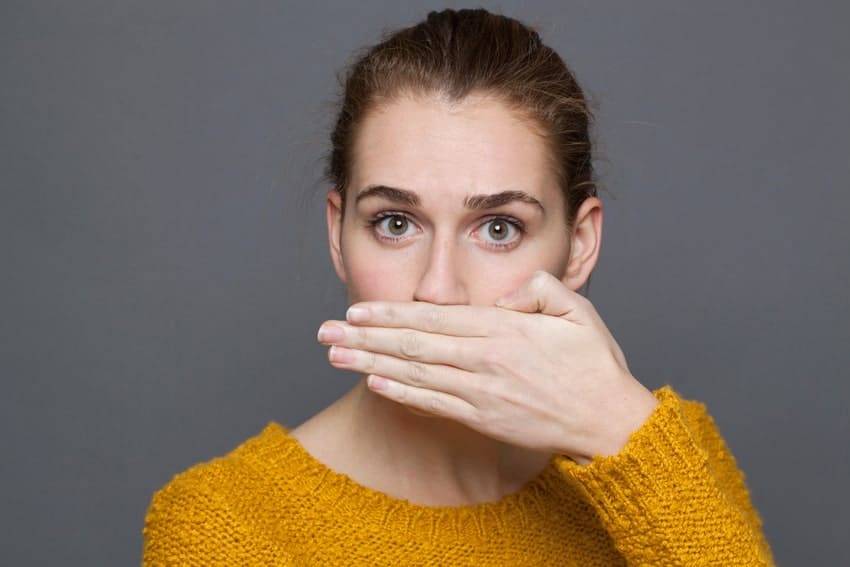 adult woman covering her mouth with her hand